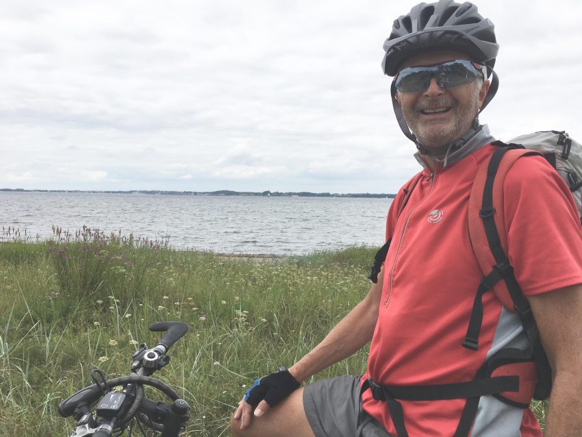 Gastgeber Mann mit Rad vor Ostsee