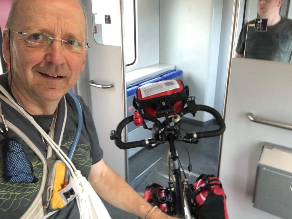 Mann mit Rad im Zug