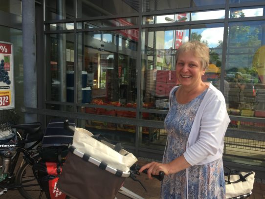 IMG_4721 Frau mit Rad vor Supermarkteingang